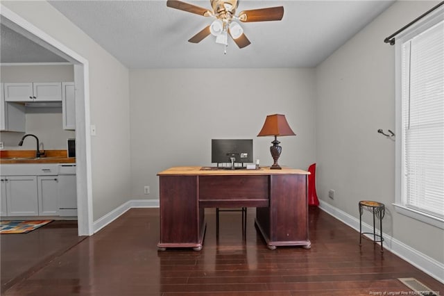 office space featuring dark wood-type flooring, ceiling fan, a healthy amount of sunlight, and sink