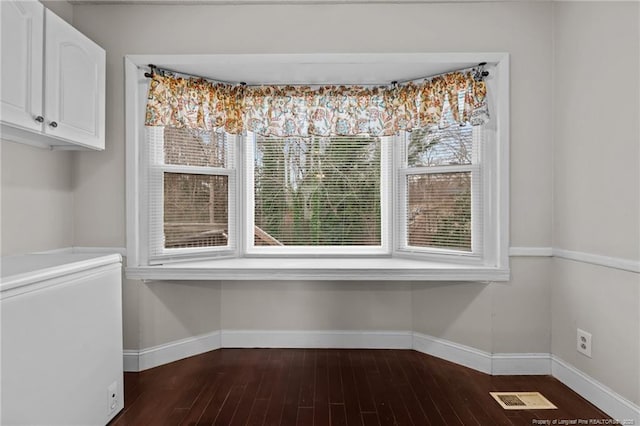 unfurnished dining area featuring dark hardwood / wood-style floors