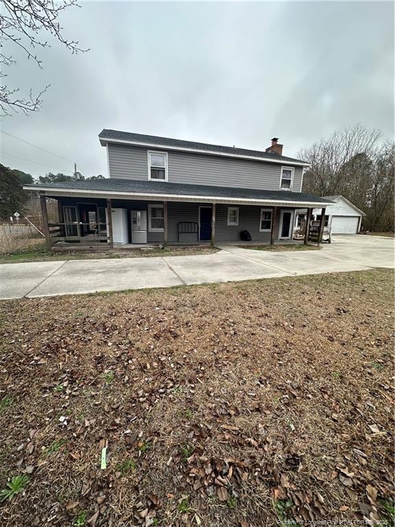 back of house featuring a garage and an outdoor structure