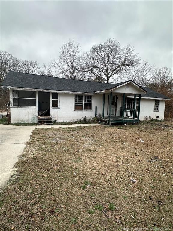 ranch-style house with a front lawn and a porch