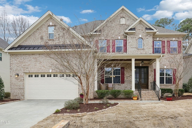 view of front of house with a porch, an attached garage, brick siding, and driveway