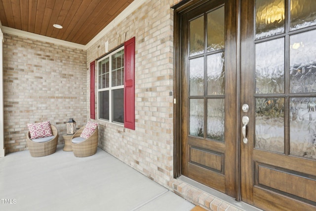 entrance to property featuring brick siding and a porch