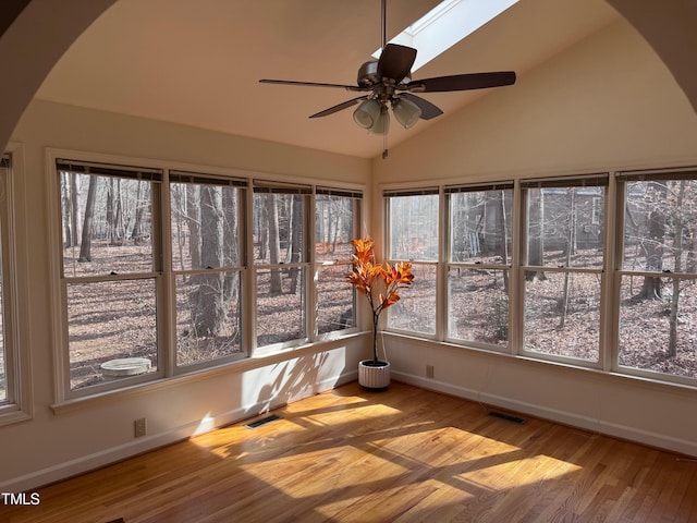 unfurnished sunroom featuring vaulted ceiling with skylight and ceiling fan