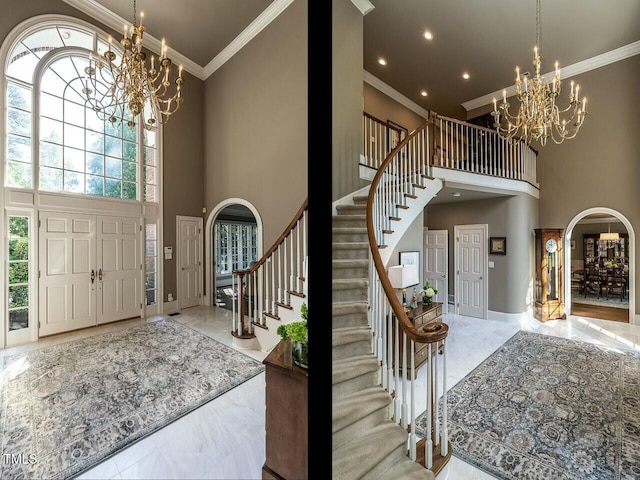 foyer featuring ornamental molding, arched walkways, a notable chandelier, and stairs