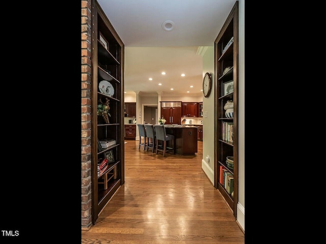 hall with recessed lighting, crown molding, and wood finished floors