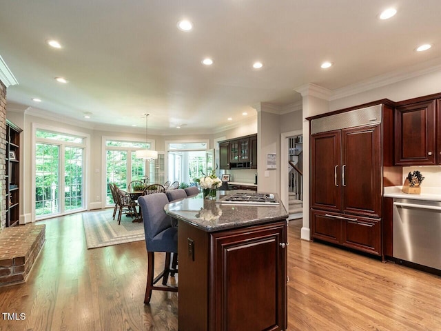 kitchen featuring light wood-style flooring, a breakfast bar, a center island, stainless steel appliances, and recessed lighting