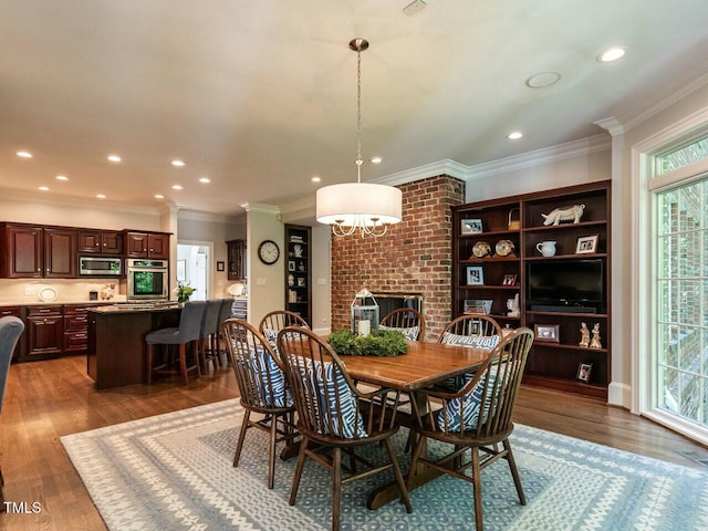 dining area featuring dark wood-type flooring, recessed lighting, crown molding, and a fireplace