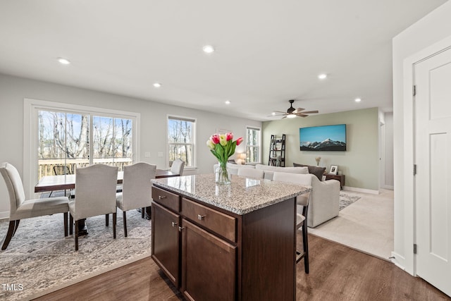 kitchen featuring dark wood-style floors, open floor plan, a kitchen island, and a breakfast bar area