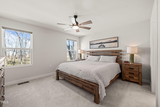 bedroom featuring light colored carpet, visible vents, ceiling fan, and baseboards