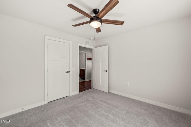 unfurnished bedroom featuring light carpet, baseboards, visible vents, and ceiling fan