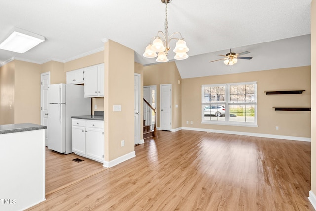 kitchen featuring white cabinetry, hanging light fixtures, light hardwood / wood-style floors, white fridge, and ceiling fan with notable chandelier