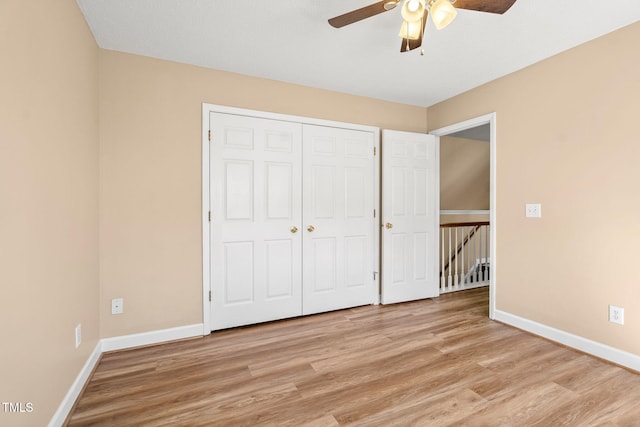 unfurnished bedroom with ceiling fan, a closet, and light wood-type flooring