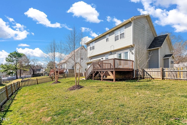 rear view of house with a wooden deck and a yard