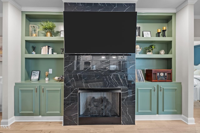 bar featuring built in shelves, a fireplace, wood finished floors, and crown molding