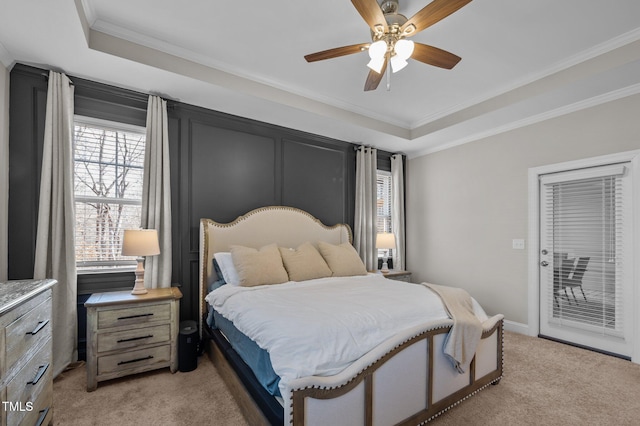 bedroom featuring access to exterior, a tray ceiling, ornamental molding, light carpet, and ceiling fan