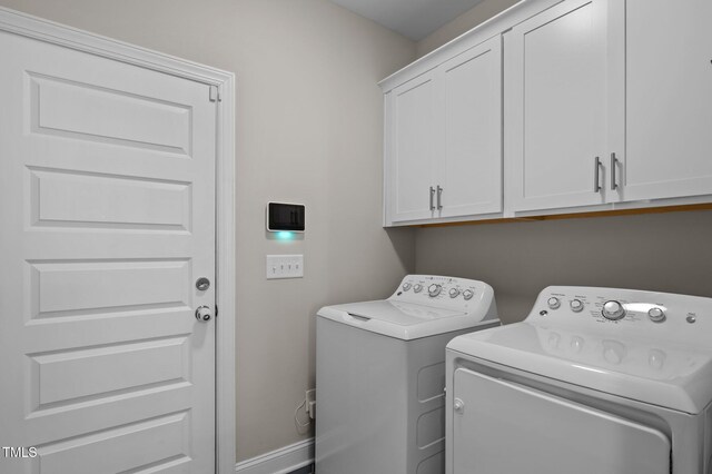 laundry room featuring cabinet space, baseboards, and washer and clothes dryer