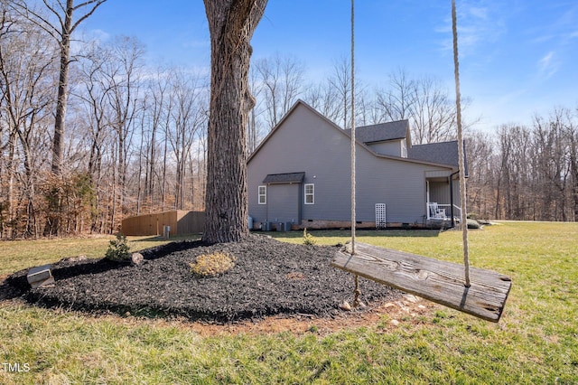 view of side of home with roof with shingles, crawl space, and a lawn