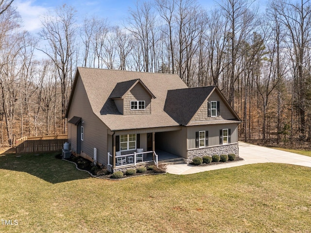 view of front facade featuring covered porch, stone siding, a front lawn, and roof with shingles