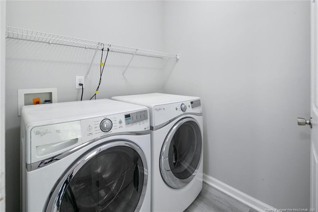 clothes washing area with hardwood / wood-style flooring and independent washer and dryer