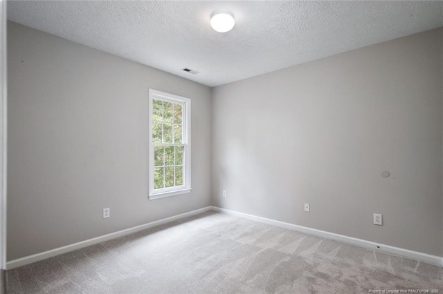 spare room featuring carpet flooring and a textured ceiling