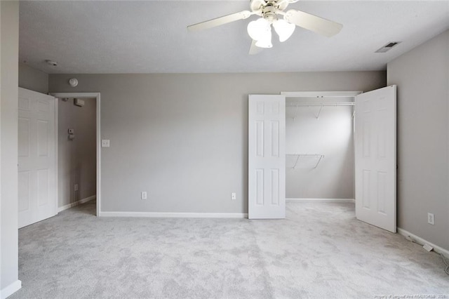 unfurnished bedroom featuring light colored carpet, ceiling fan, and a closet