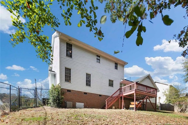 rear view of house featuring a wooden deck