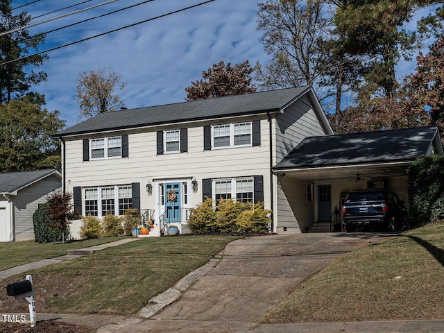 colonial inspired home featuring a front lawn and a carport