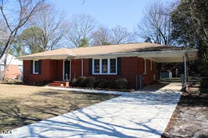 ranch-style home with a carport and driveway