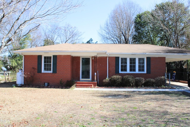 ranch-style home featuring entry steps, a carport, and brick siding