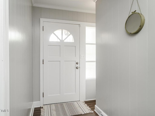 foyer with plenty of natural light, dark wood-type flooring, and crown molding