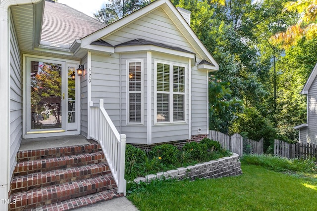 property entrance featuring a lawn