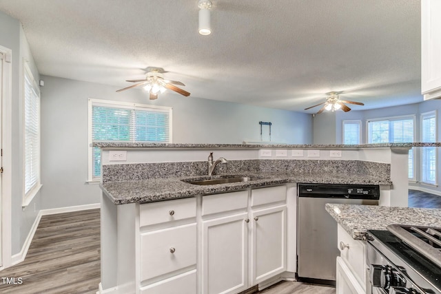 kitchen featuring stainless steel appliances, sink, white cabinets, and stone counters