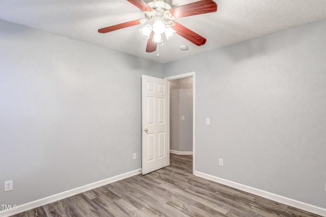 spare room with ceiling fan, wood-type flooring, and a textured ceiling