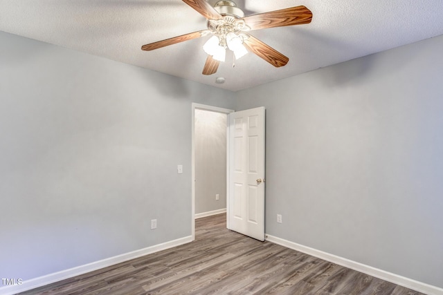 empty room with ceiling fan, hardwood / wood-style floors, and a textured ceiling