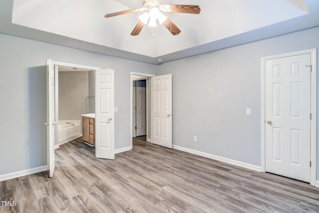 unfurnished bedroom featuring ceiling fan, connected bathroom, and light hardwood / wood-style floors