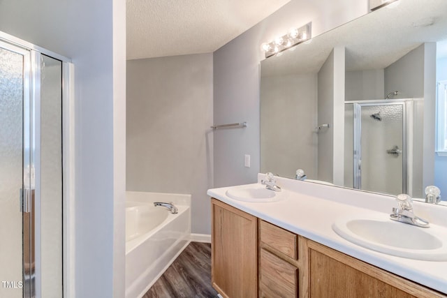 bathroom with hardwood / wood-style flooring, vanity, shower with separate bathtub, and a textured ceiling