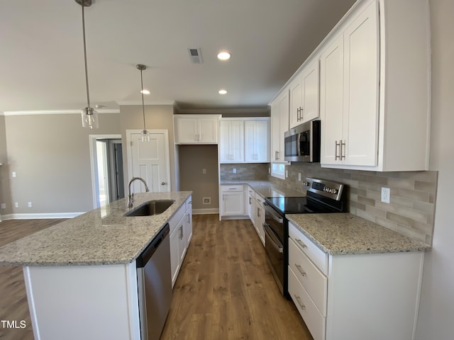 kitchen with decorative backsplash, white cabinets, visible vents, stainless steel appliances, and a sink