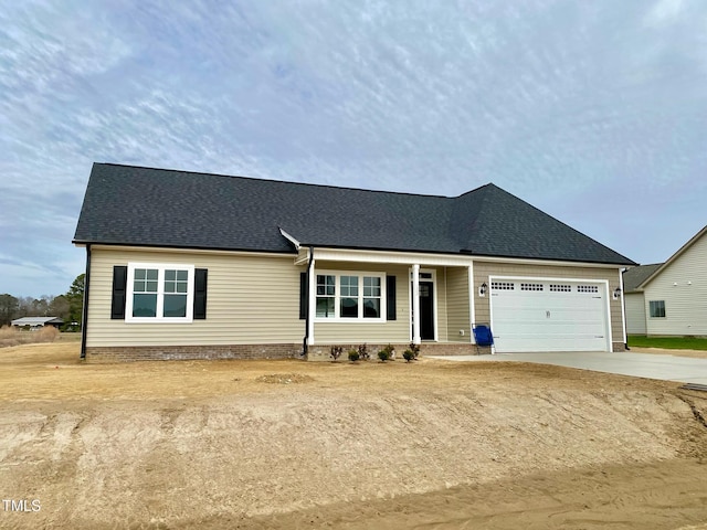 ranch-style home with driveway, roof with shingles, and an attached garage