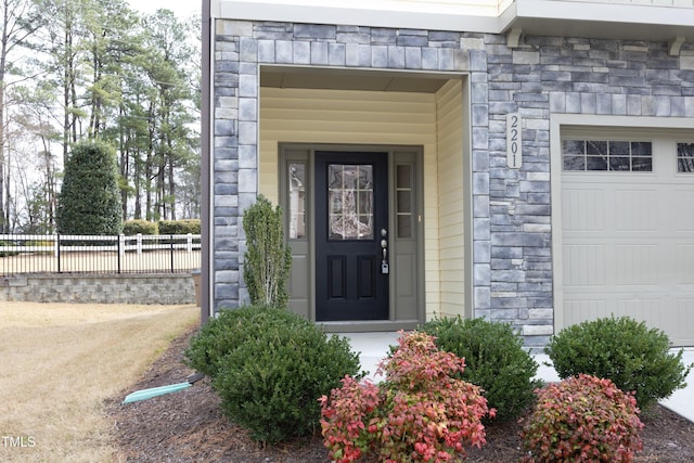 property entrance with stone siding and fence