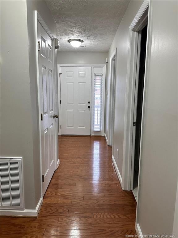 doorway featuring hardwood / wood-style flooring and a textured ceiling