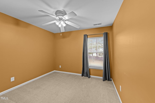 empty room featuring ceiling fan and light colored carpet