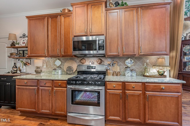 kitchen featuring stainless steel appliances, ornamental molding, tasteful backsplash, and dark wood-type flooring