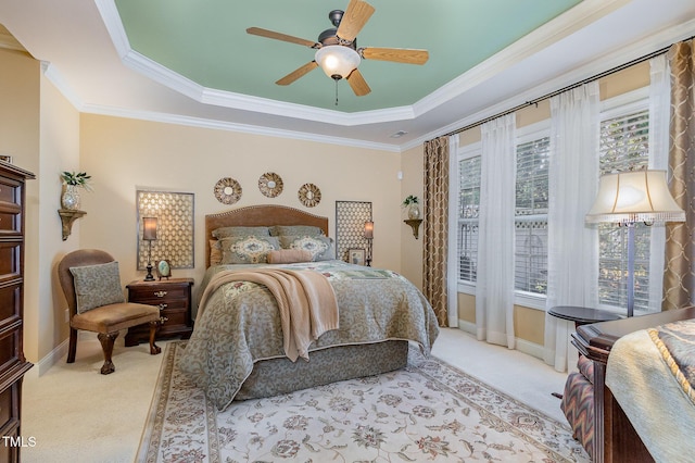 bedroom featuring ornamental molding, light colored carpet, a raised ceiling, and multiple windows