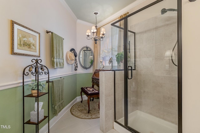 full bathroom featuring crown molding, an inviting chandelier, tile patterned flooring, and a stall shower