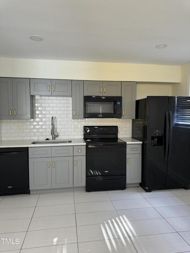 kitchen featuring gray cabinets, sink, backsplash, and black appliances