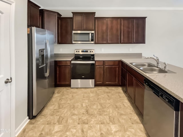 kitchen with ornamental molding, stainless steel appliances, and sink