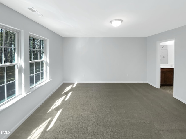 spare room with dark colored carpet