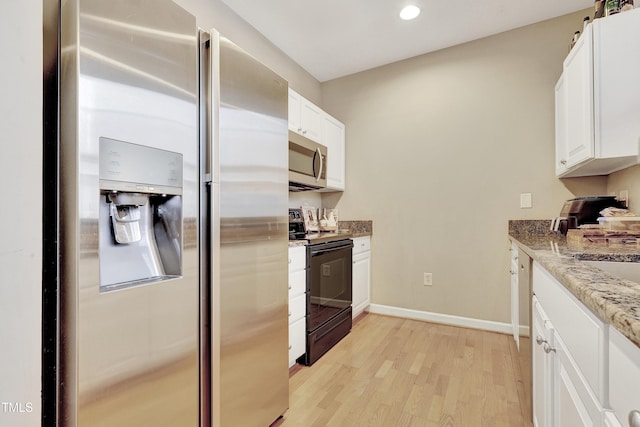 kitchen featuring stainless steel appliances, white cabinetry, light stone counters, and light hardwood / wood-style floors