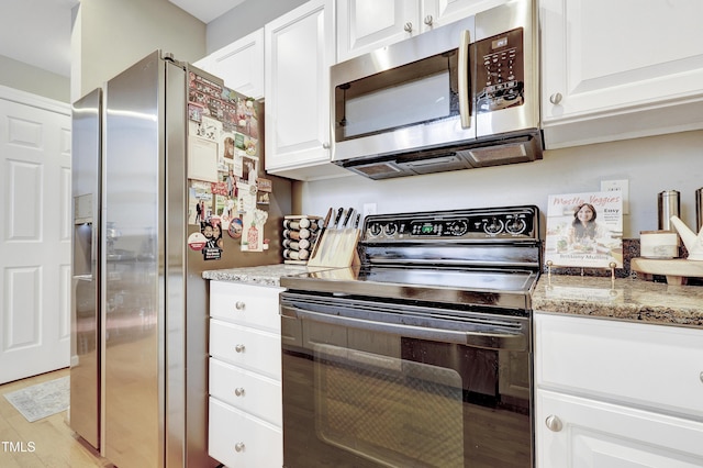 kitchen featuring white cabinetry, light hardwood / wood-style flooring, light stone countertops, and appliances with stainless steel finishes