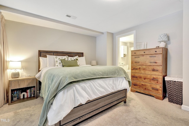 bedroom featuring light carpet and ensuite bathroom